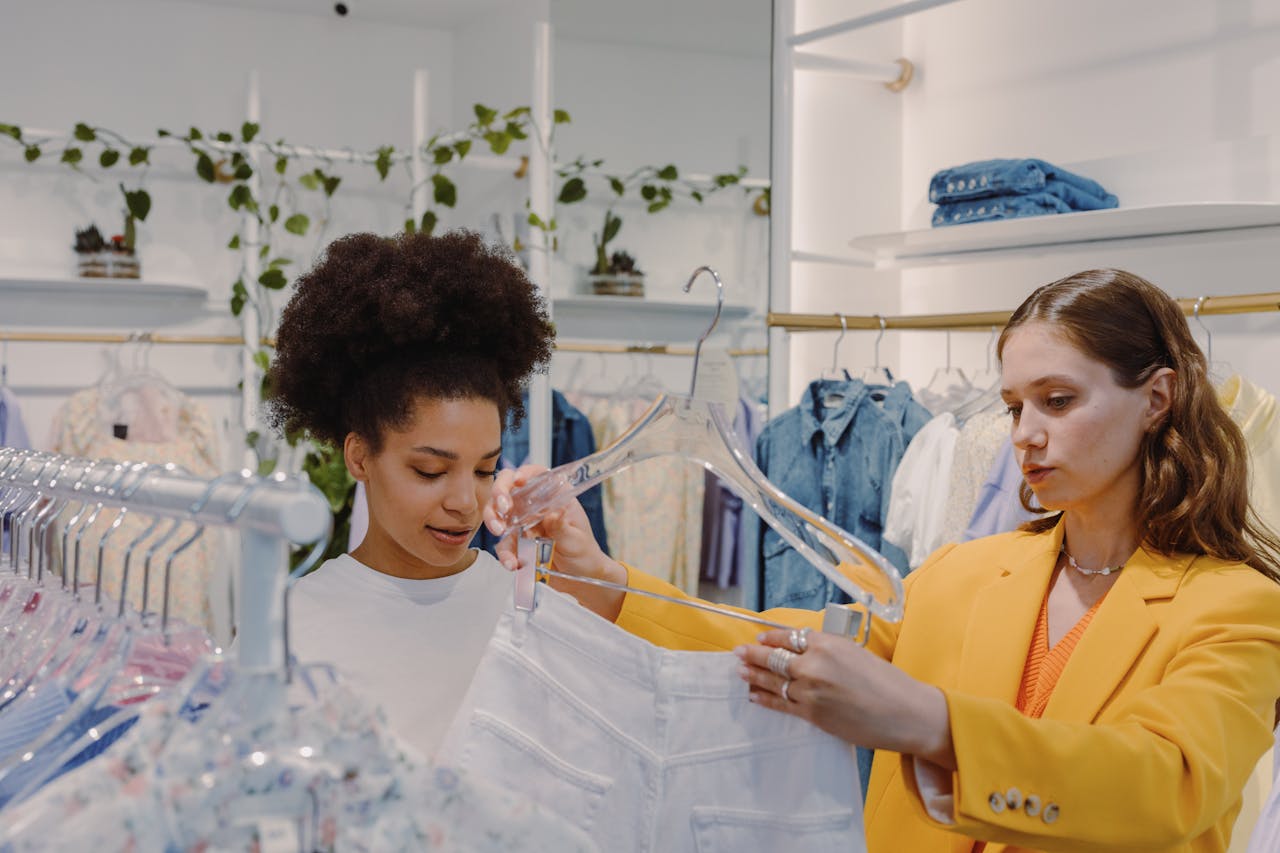 Two women exploring fashion choices in a stylish clothing store.