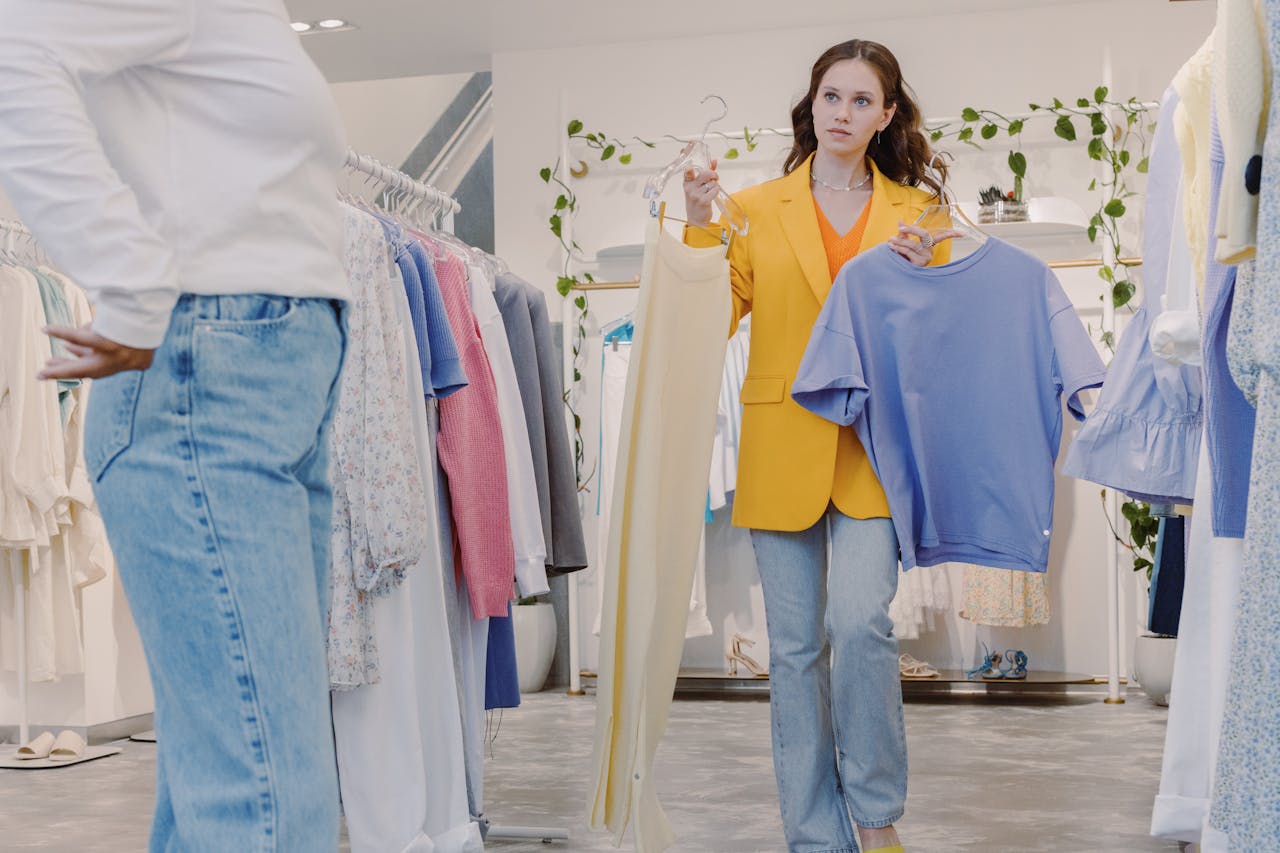 Woman shopping in boutique holding clothes for fitting in a modern fashion store.